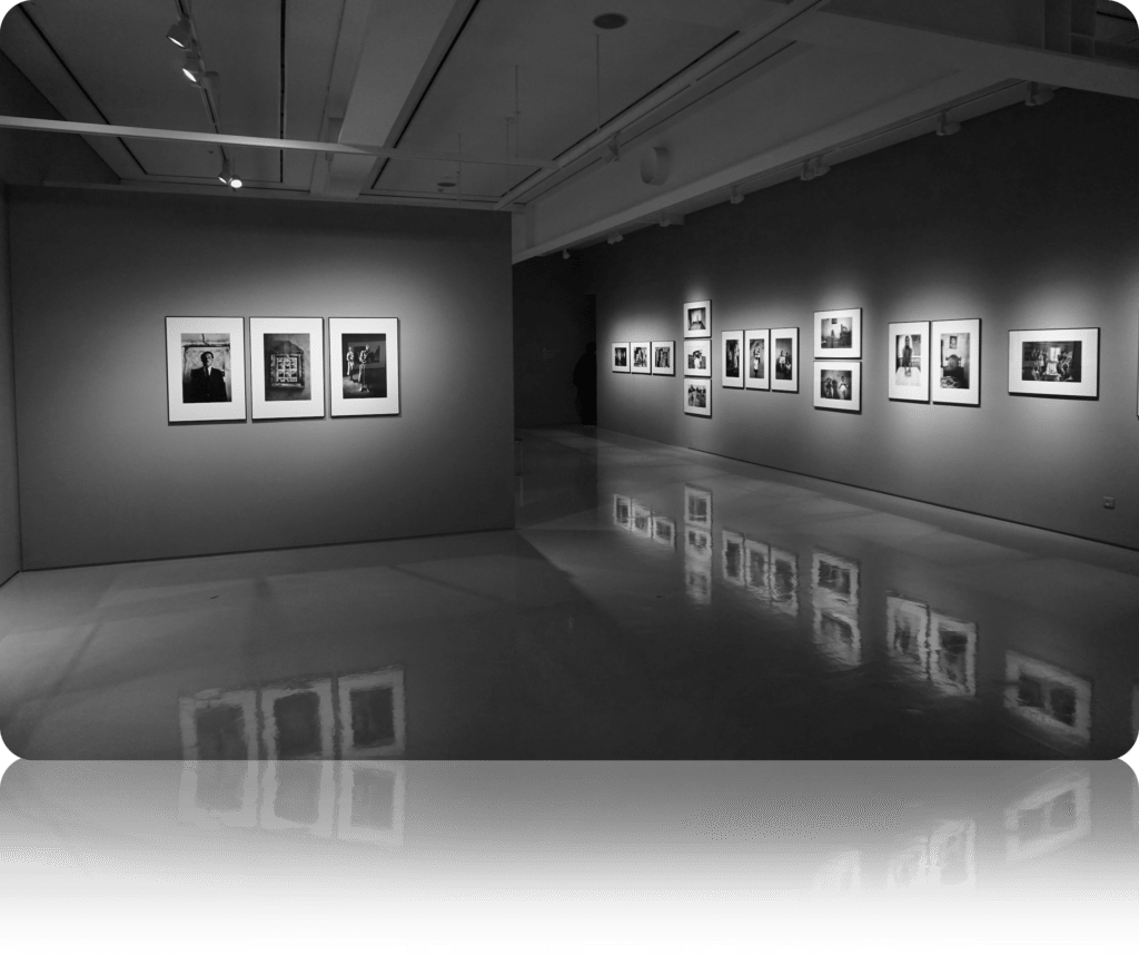 Image of art gallery with artwork on the wall, under spotlights